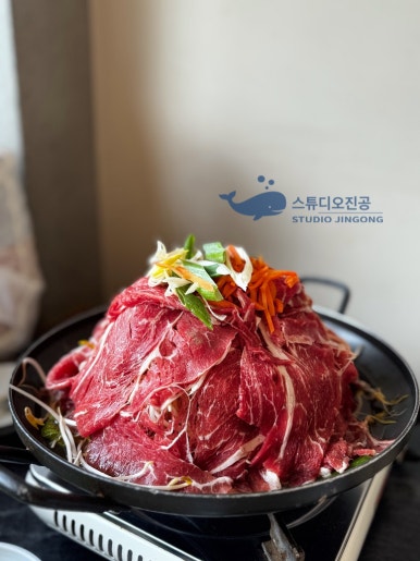 채소 위에 얇게 썬 고기가 높이 쌓인 종로회관의 산더미 불고기