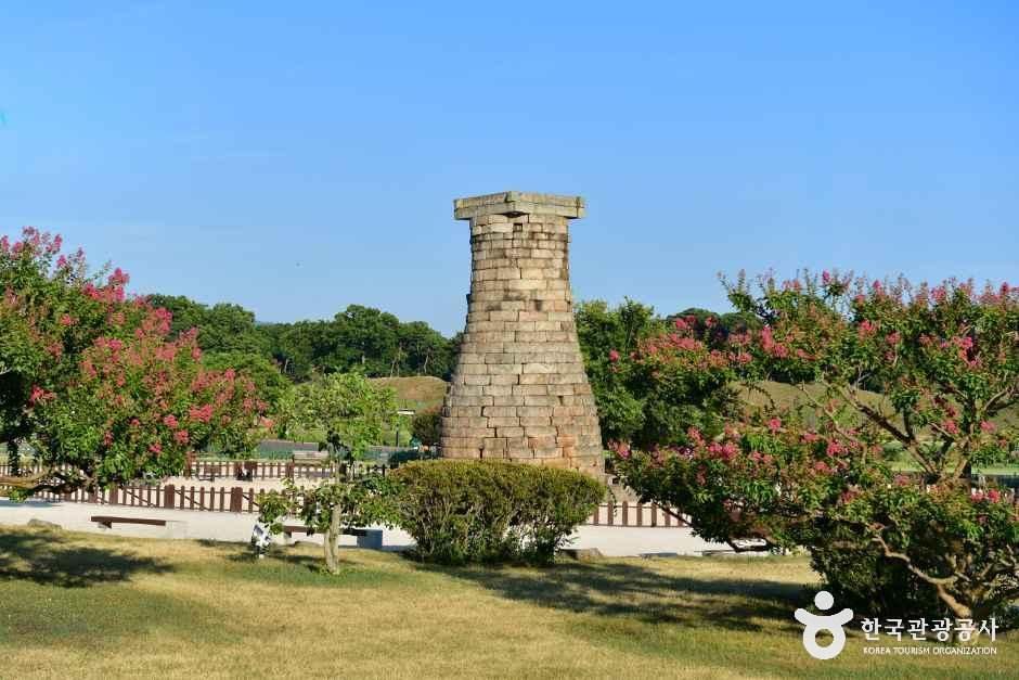 푸른 하늘과 꽃나무 사이의 경주 첨성대